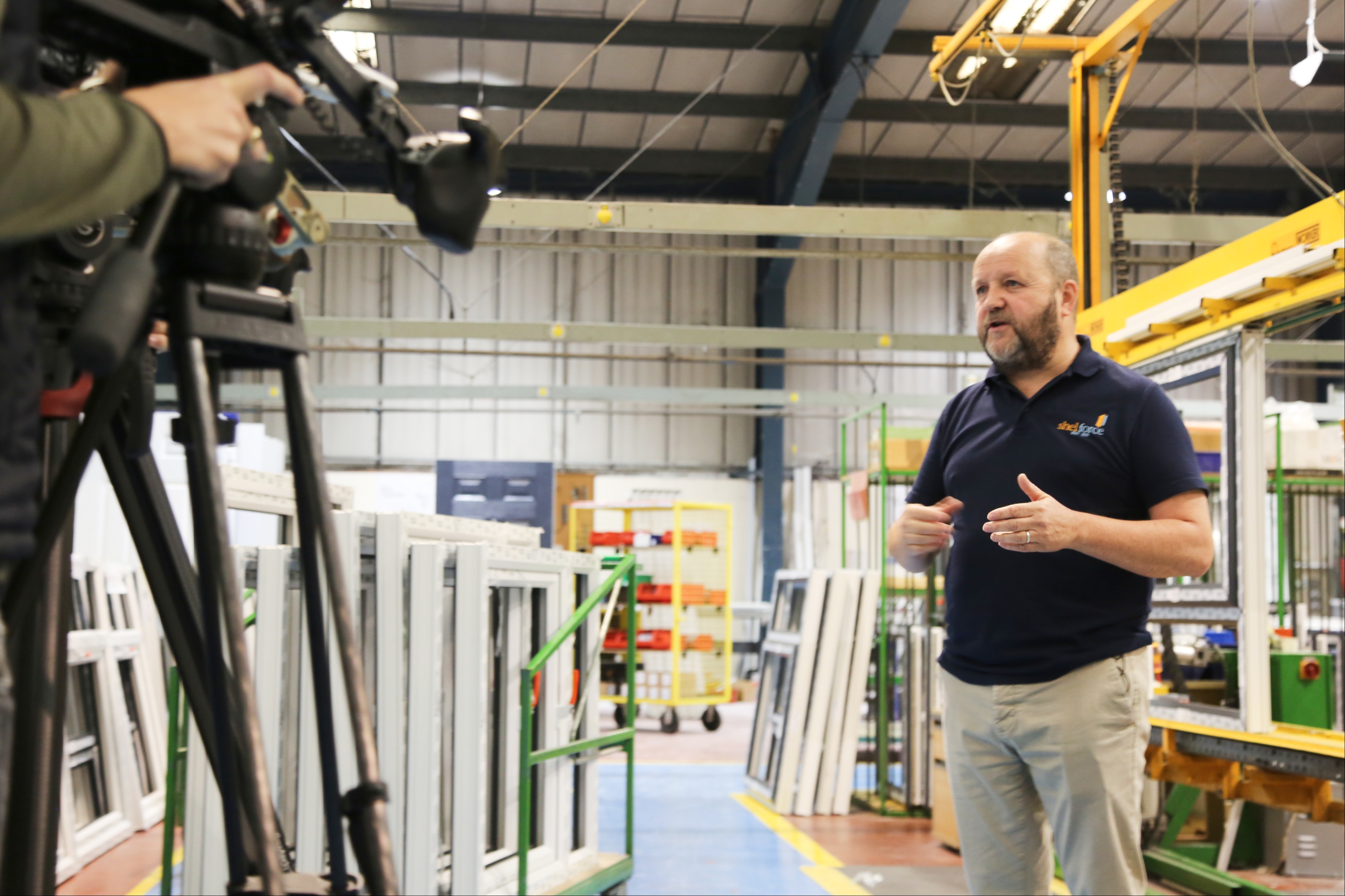 camera interview of manager inside window production factory