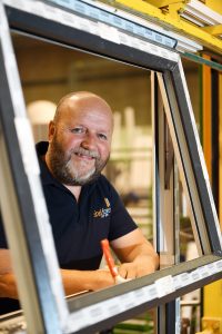 Worker standing in a window frame