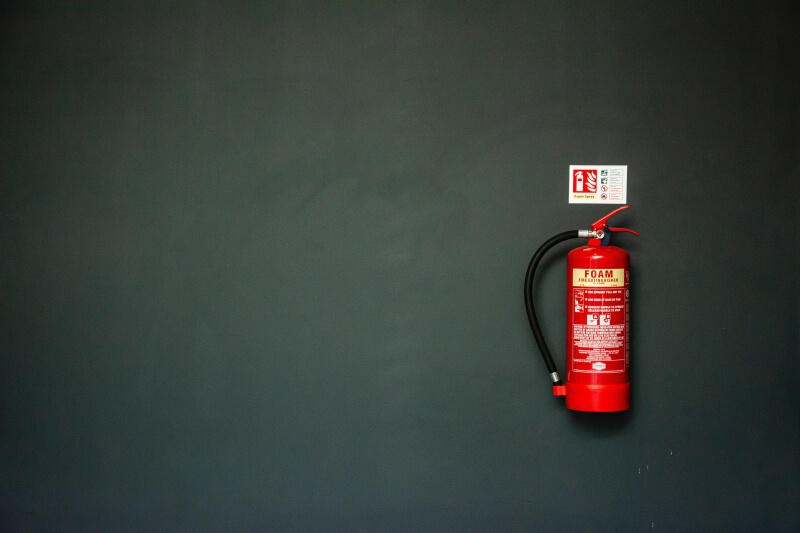 birdseye shot of red fire extinguisher on green background