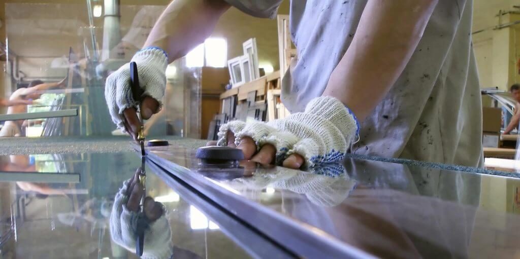 Worker cutting glass down to size for PVCu windows