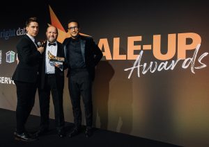 PROUND WINNER: Howard Trotter, Shelforce’s Business Manager on stage with his award flanked by Russell Kane (left) and Dan Barber, judge and Director of Brand Strategy of ClearCourse.